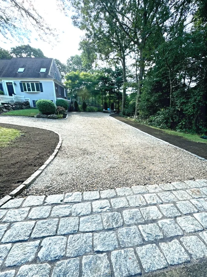 Stone-edged gravel driveway with cobblestone apron installed by Evergreen Landscaping in Falmouth, MA
