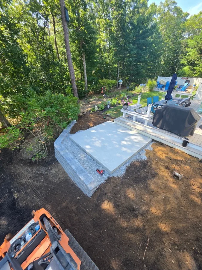 Retaining wall and concrete pad site preparation for a backyard hot tub on Cape Cod